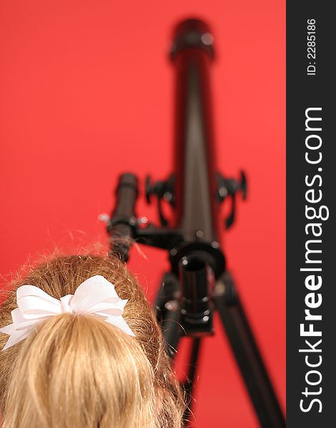 Shot of a young girl looking thru telescope