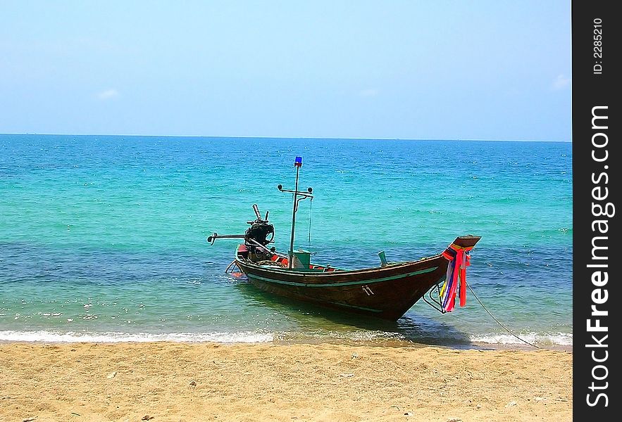 Thai longtailboat with bright ribbons in turquoise waters