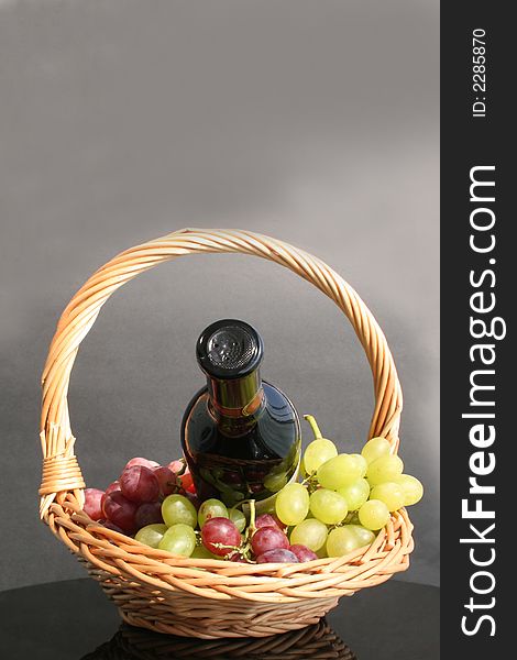 Wine bottle and grapes in the basket