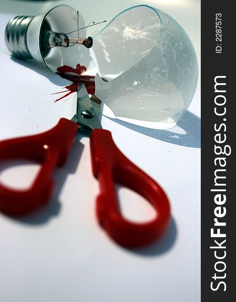 Broken light bulb with scissors and blood. Broken light bulb with scissors and blood.
