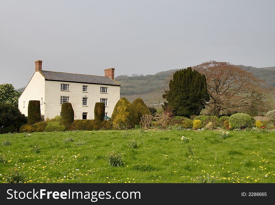 Rural English Farmhouse with a Meadow full of Spring Flowers in the foreground