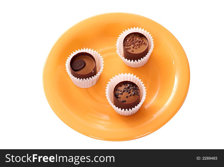 Three small candies on an orange plate