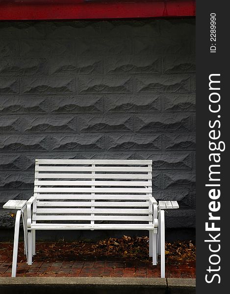 White park bench with gray brick background