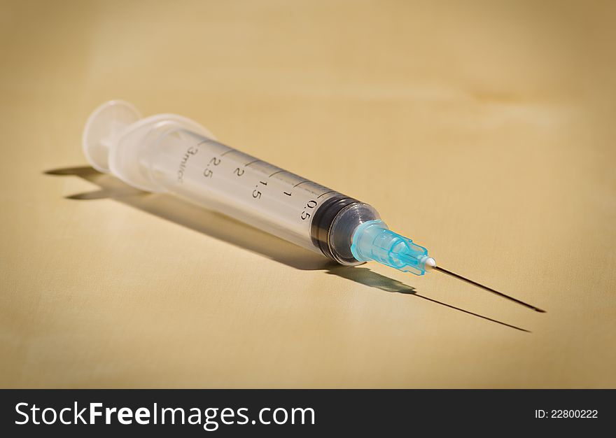 New empty disposable syringe on a beige background