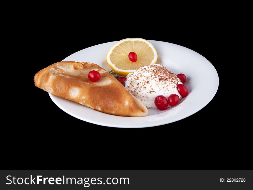 Pancake with ice cream and fruts on plate, isolated on black background