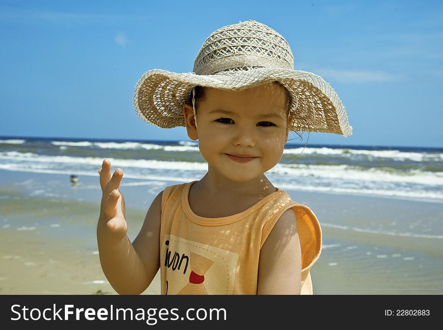 A child wearing a hat against the sea