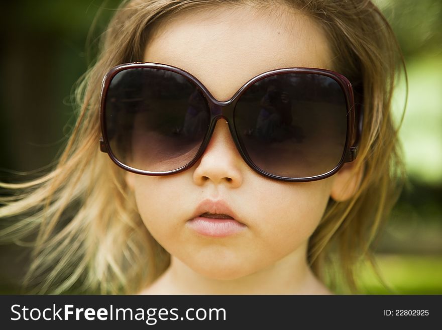 The little girl wears a large adult sunglasses, Asian-mestizo