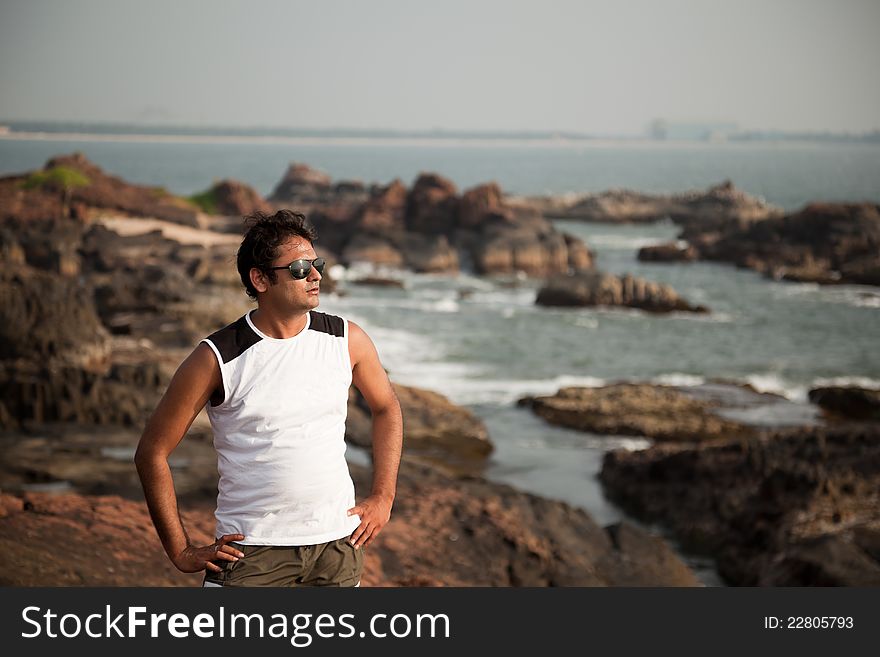 Indian Happy young man getting out of the water with sunglasses. Indian Happy young man getting out of the water with sunglasses