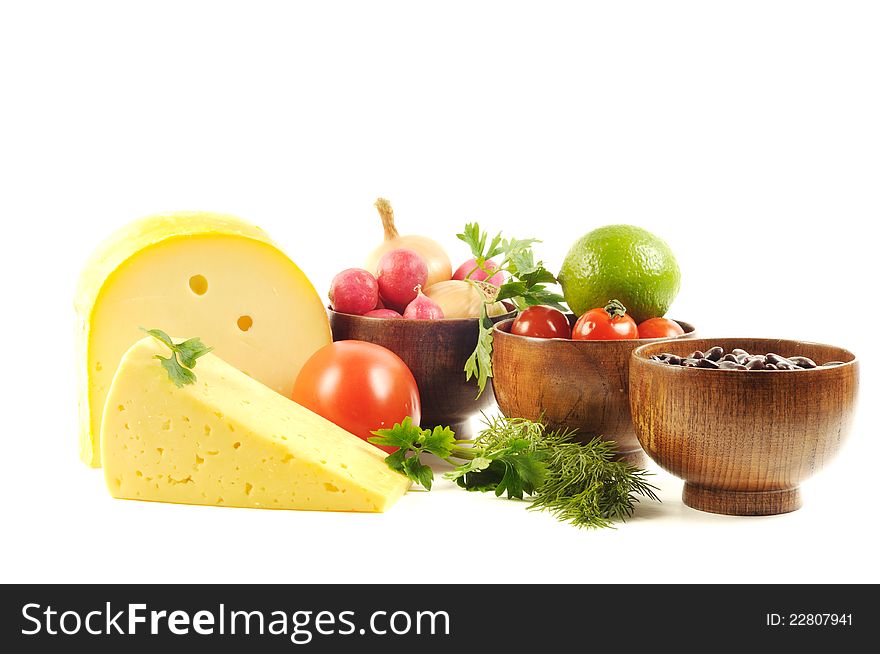 Assortment of cheese and some vegetables on a white background. Assortment of cheese and some vegetables on a white background