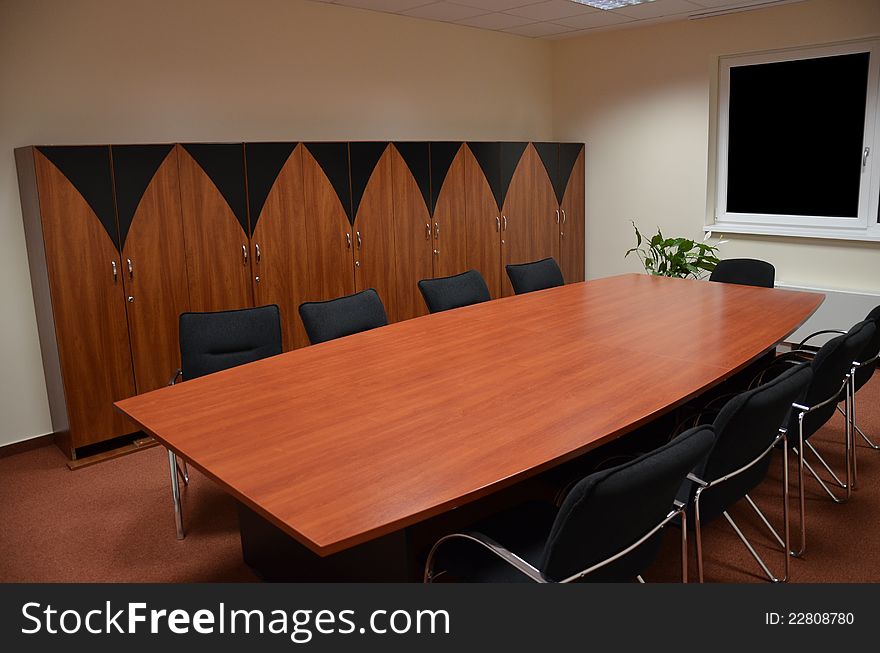 Meeting room with chairs cupboards and a table