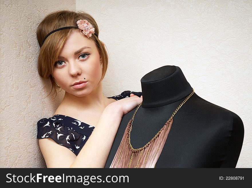 Girl posing near mannequin in seamstress's workshop