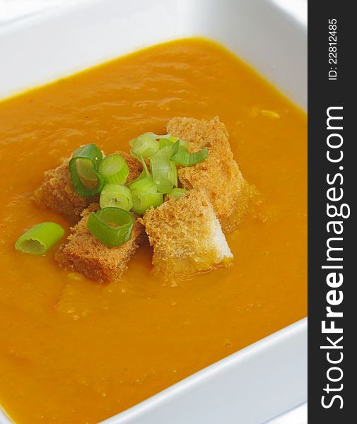 Pumpkin soup with crackers and onion