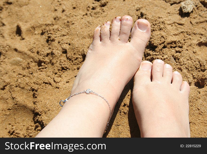 Tanned legs of a child on sand. Tanned legs of a child on sand