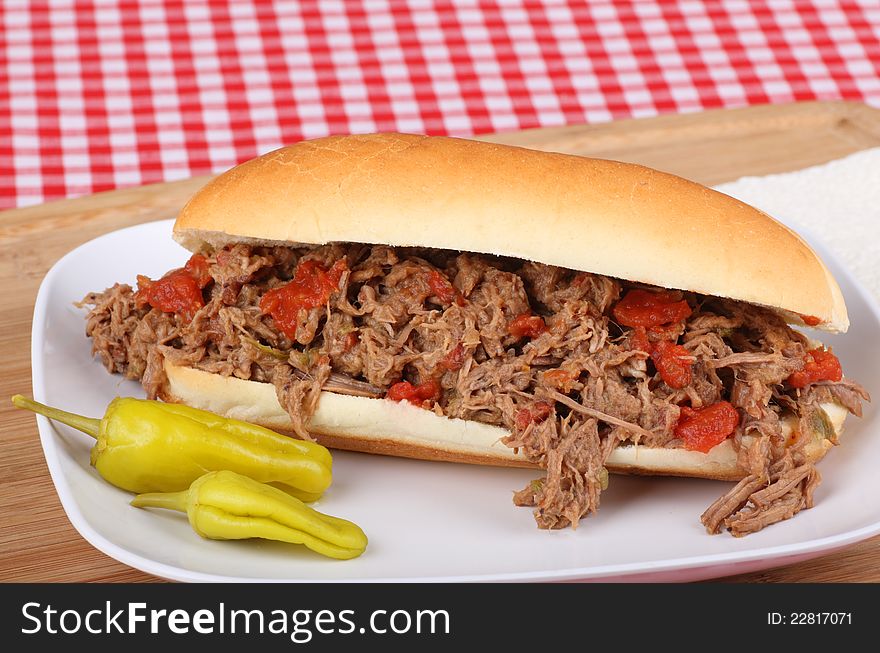 Shredded roast beef sandwich with peppers on a plate