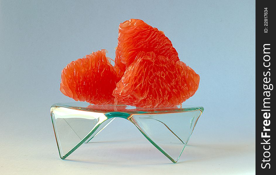 Photo red grapefruit on a glass pedestal.