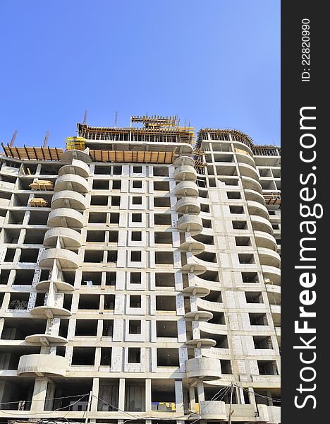 A multi-storey building under construction against a blue sky background