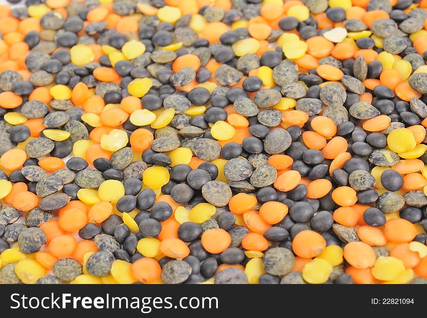 Black, orange and yellow lentils as a background