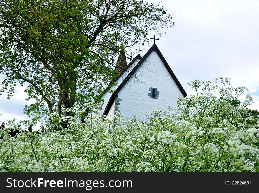 White stone church surrounded by flowers. White stone church surrounded by flowers