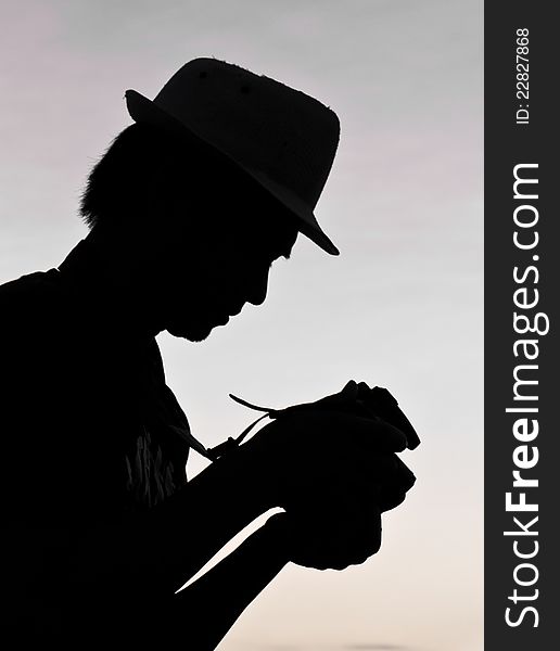 Photographer silhouette, staring at a camera review. Photographer silhouette, staring at a camera review.