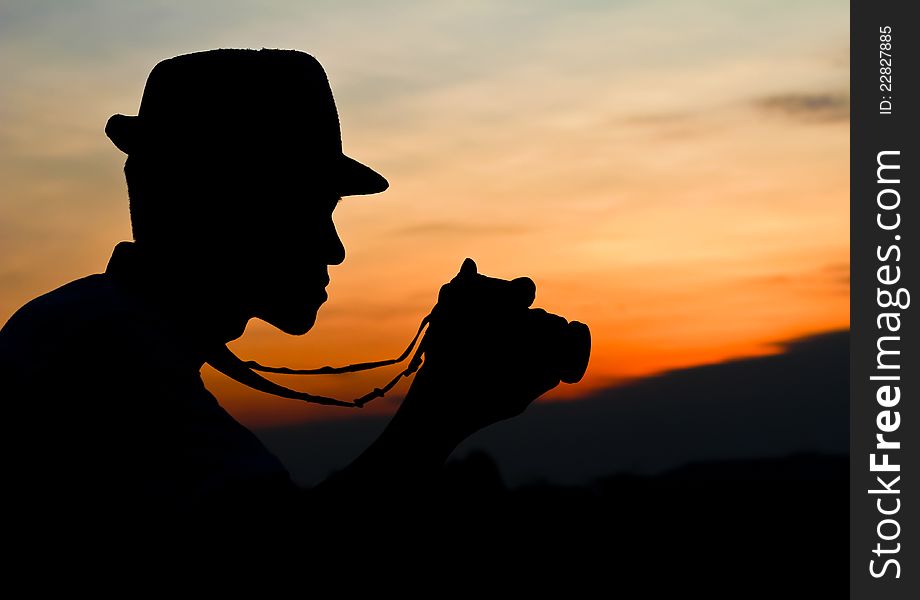 Photographer silhouette, staring at a camera review. Photographer silhouette, staring at a camera review.