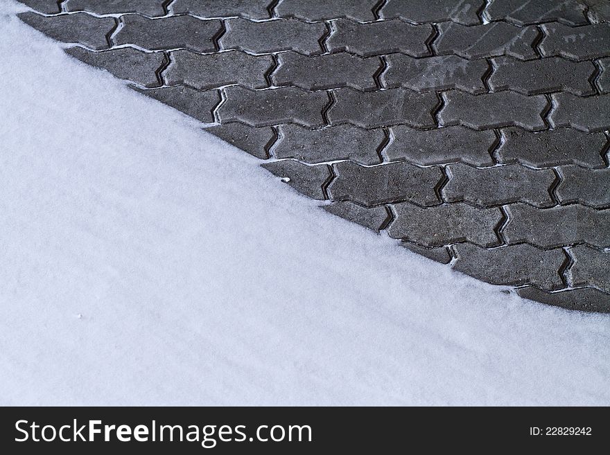 Grey brick wall partly covered by snow. Grey brick wall partly covered by snow.