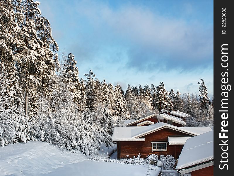 Log cabin houses in snowy winter forest scenery. Log cabin houses in snowy winter forest scenery