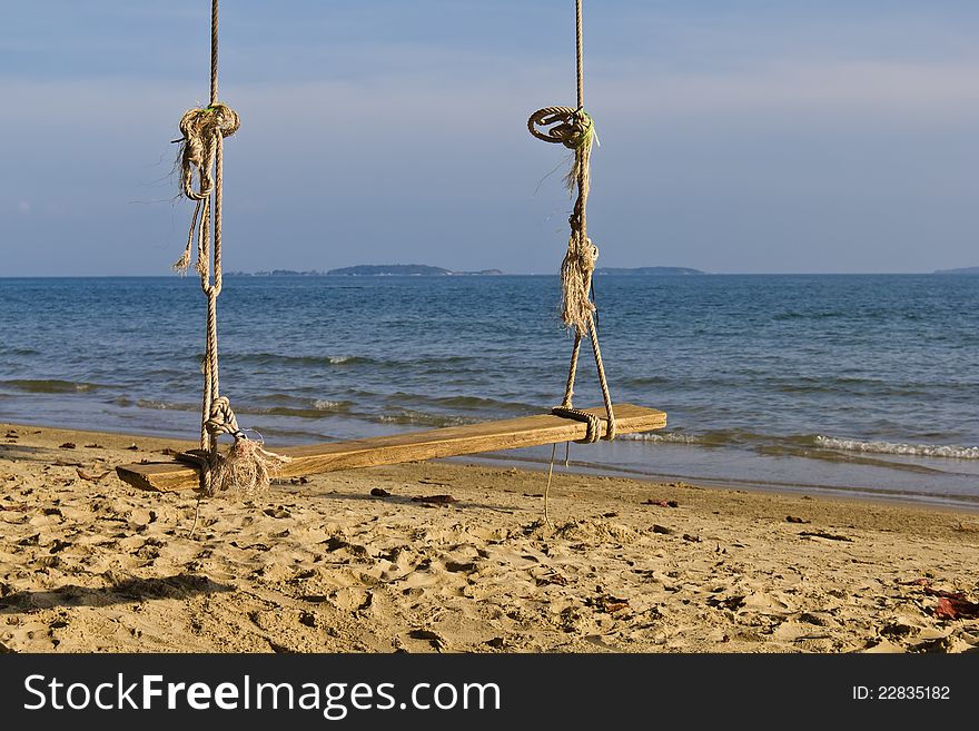 A lonely swing on the beach in the evening