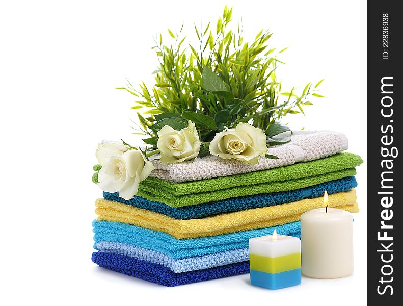 Spa towels with white rosesand burn candles isolated on white background