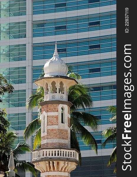 Minaret of mosque with abstract building background