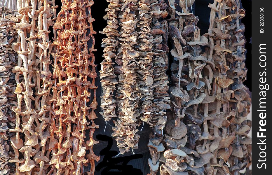 Photo of dried mushrooms like stringed on the rope and put up for sale. Photo of dried mushrooms like stringed on the rope and put up for sale