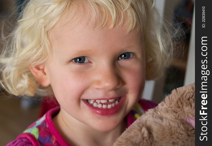 Smiling beautiful little girl with her teddy bear just before bed time. Smiling beautiful little girl with her teddy bear just before bed time