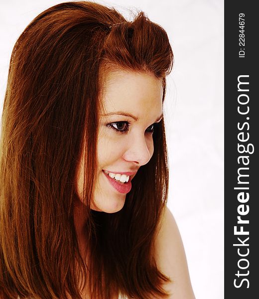 Side facial view of beautiful brunette woman with inquisitive romantic smile. Light out of focus background. Side facial view of beautiful brunette woman with inquisitive romantic smile. Light out of focus background.