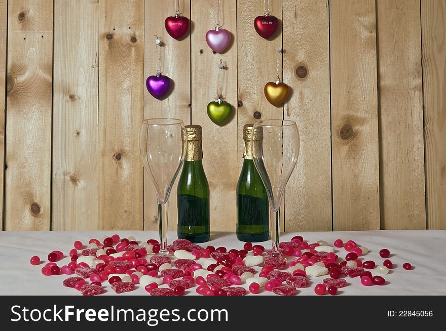 Candy harts,jelly beans and champagne on white and wood background. Candy harts,jelly beans and champagne on white and wood background