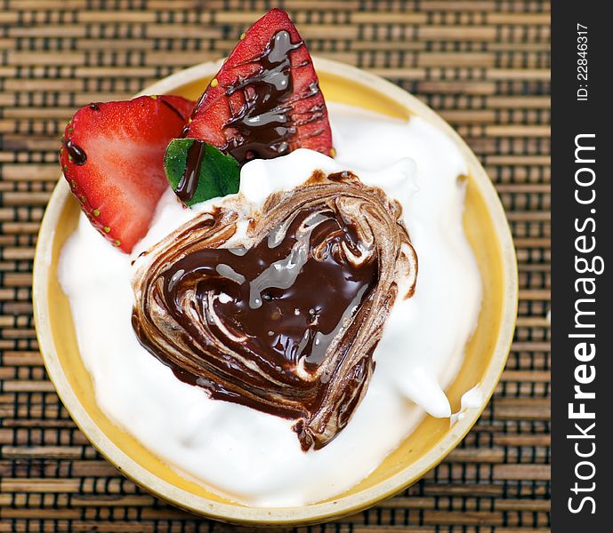 Delicious dessert with whipped creme and strawberry decorated chocolate heart. Delicious dessert with whipped creme and strawberry decorated chocolate heart