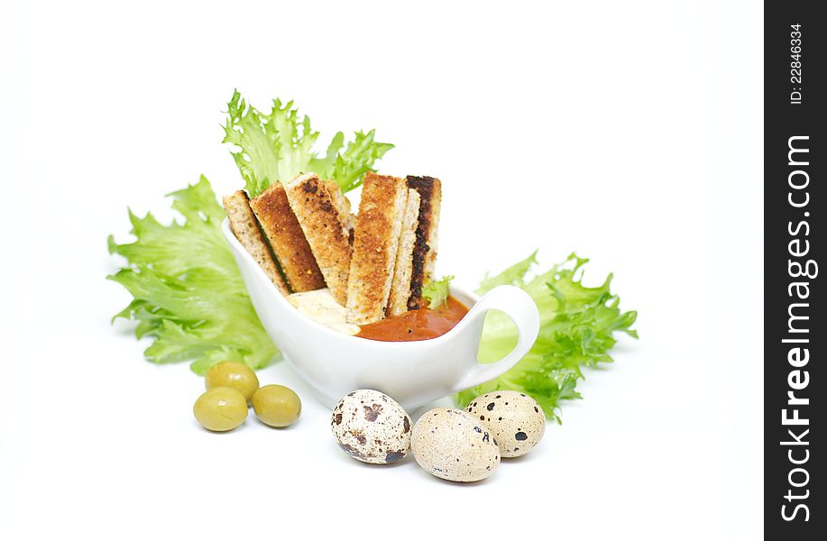 Snack from crackling bread with cheese sauce and a BBQ ketchup, leaves of salad and olives