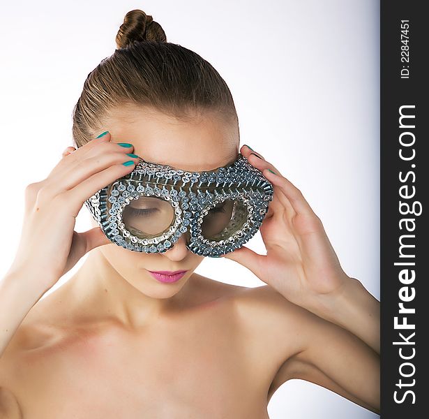 Pretty young woman in metallic silver binoculars - with lots of screw. Studio shot, series of photos. Pretty young woman in metallic silver binoculars - with lots of screw. Studio shot, series of photos