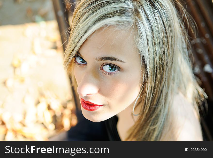 Pretty girl sitting in a bench in the park