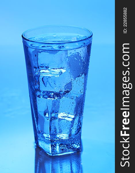 Crystal clear water with ice over blue background