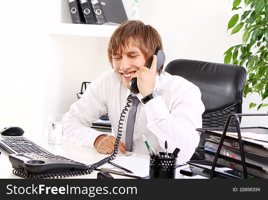 Young and successful businessman talking by phone in his office