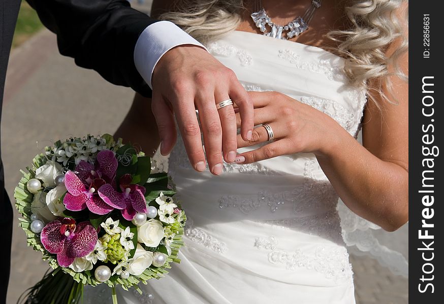 Portrait of two pairs of beautiful hands of bride and groom on the background of fabulous bouquet of flowers. Portrait of two pairs of beautiful hands of bride and groom on the background of fabulous bouquet of flowers