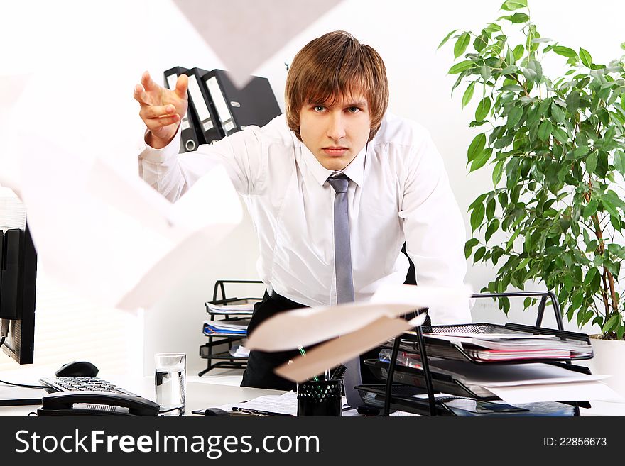 Angry businessman with documents in his office. Angry businessman with documents in his office