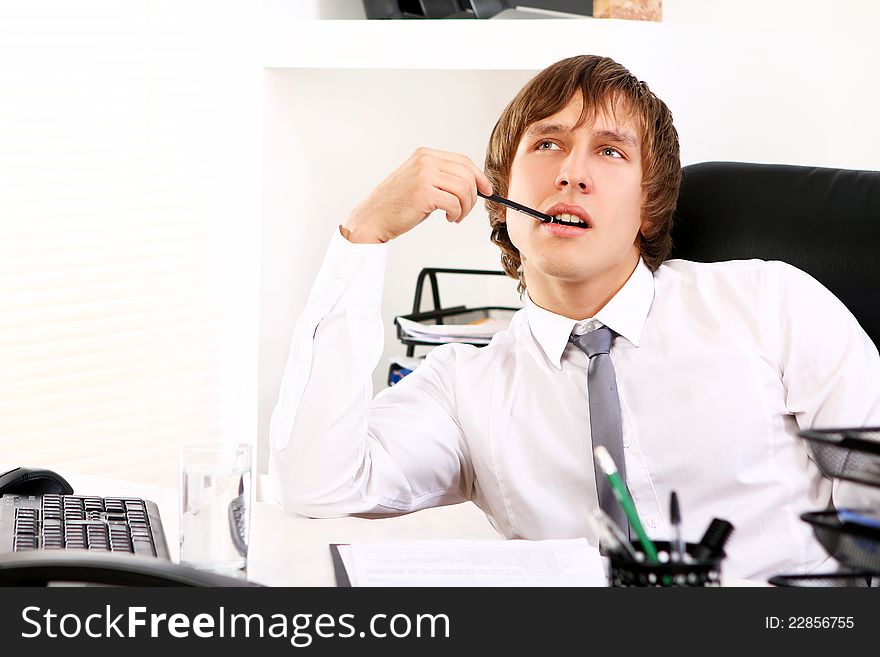 Young businessman thinking in office