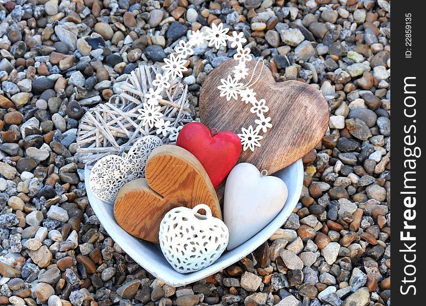 A selection of hearts in a bowl on pebbles. A selection of hearts in a bowl on pebbles