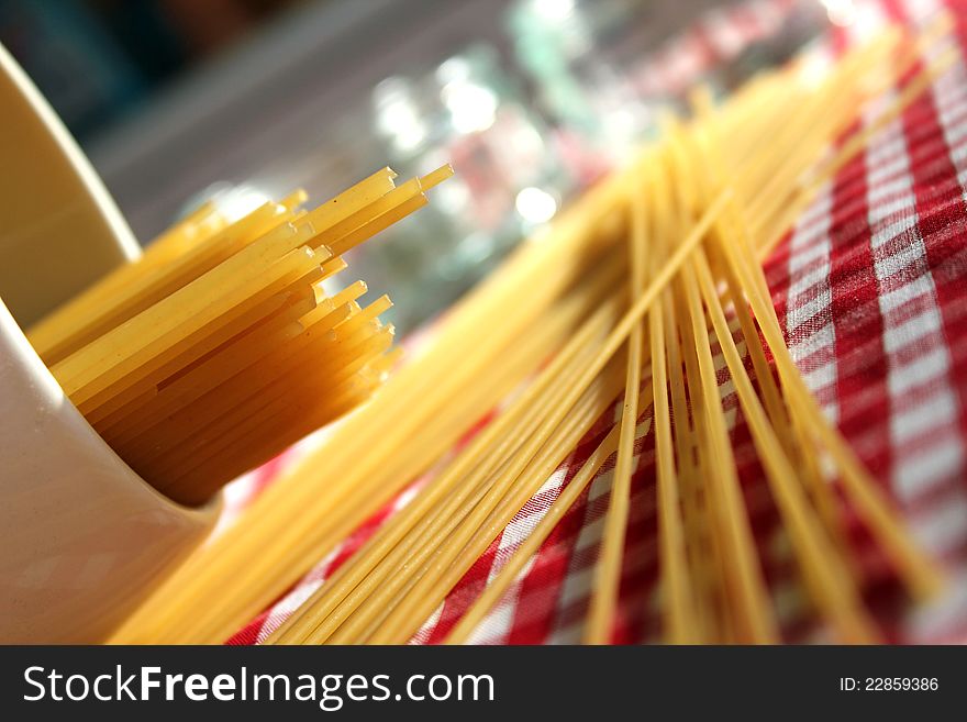 This photo shows a close-up of dried spaghetti spilled out on the table. This photo shows a close-up of dried spaghetti spilled out on the table