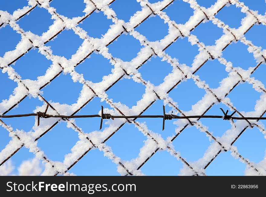 A fragment of a fence with barbed wire