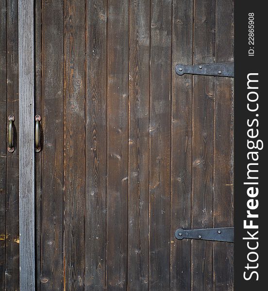 Large, old, wooden door, with metal handles and hinges