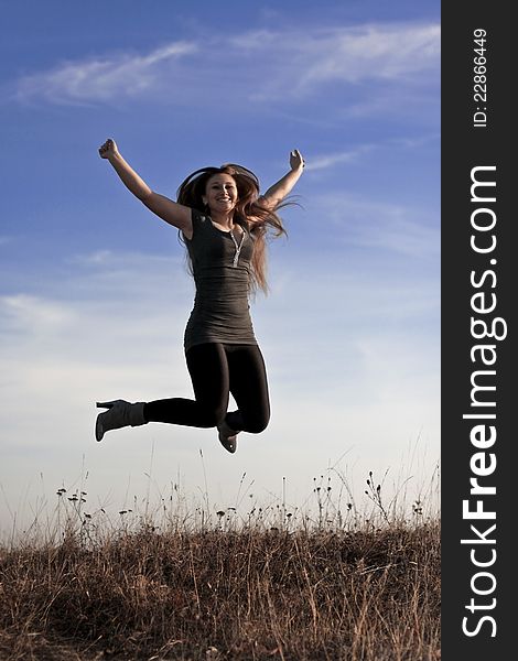 Beautiful girl jumps against the blue sky. Beautiful girl jumps against the blue sky