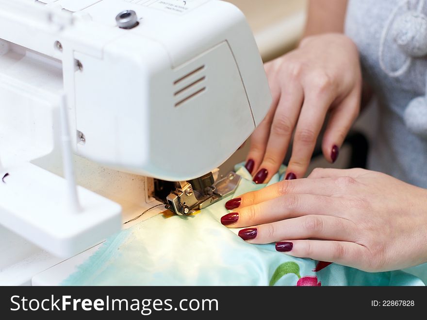 Female hands working on a sewing machine