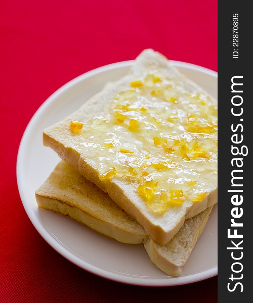 Orange marmalade bread on the red floor..