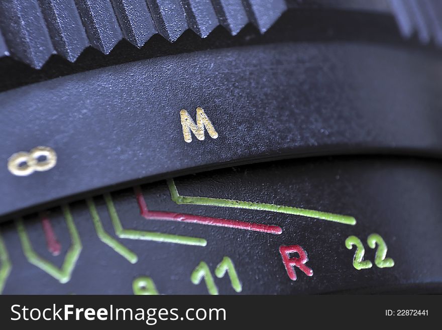 Closeup of vintage photo-camera lens; selective focus on M letter. Closeup of vintage photo-camera lens; selective focus on M letter